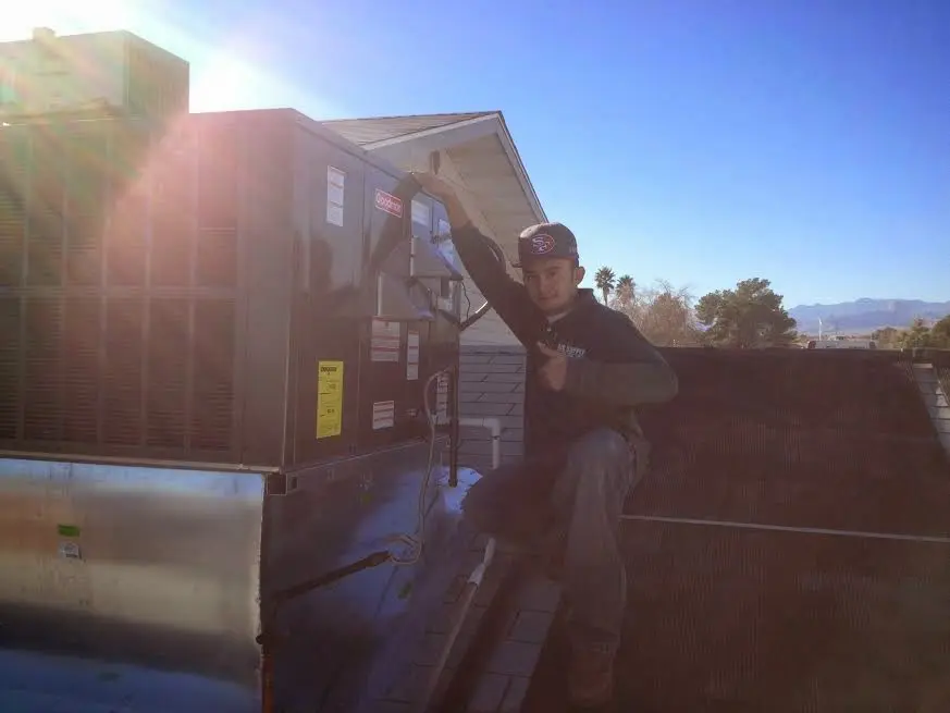 HVAC technician performing AC Tune-Up on a rooftop unit in Lisle